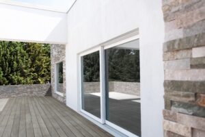 Scorrevole in PVC bianco su terrazza in legno
